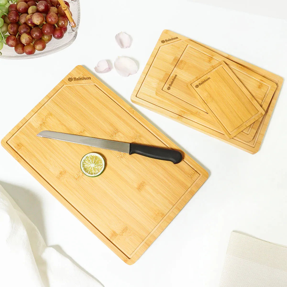 Bamboo cutting boards with a knife and lime on a white surface